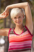 A mature blonde woman with short hair outside wearing a striped top