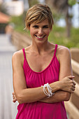 A mature blonde woman with short hair outside wearing a purple top