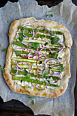 Asparagus pizza with ricotta, red onions and pine nuts