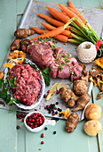 an arrangement of elk meat, vegetables, mushrooms and lingon berries