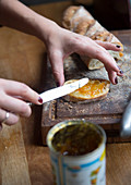 A woman spreading marmalade on a slice of bread