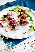 Pork skewers with bacon and red onions