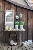 Potted plants, stones and window on old sewing machine base on terrace