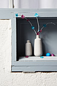 Branches decorated with paper flowers in vase