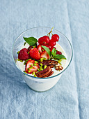 Vanilla yoghurt in a glass with berries and pecan nuts