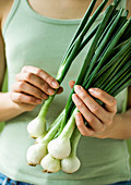 Spring onions held in the hand