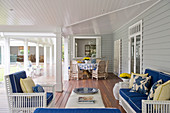 Sofa set and dining table decorated in blue and yellow on veranda
