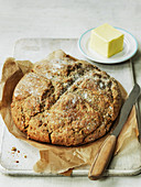 A loaf of Irish Soda Bread and butter with knife