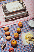 Zutaten für versunkenen Apfelkuchen auf kariertem Tischtuch