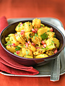 Indian bombay potatoes with pomegranate seeds cumin seeds and coriander