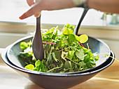 Herb salad being mixed