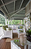 White rattan furniture with green cushions on veranda