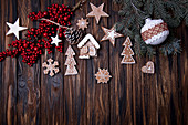 Christmas wooden background with branch of tree, holly berries, Christmas ball and gingerbread cookies