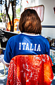 Frau sitzt im Schatten vor Wohnwagen (Italien)