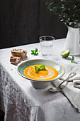 Orange pumpkin soup served on rustic table