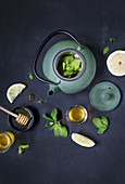 Tea pot with fresh leaves and lemon