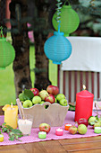 A table laid for a garden party with fresh apples and candles