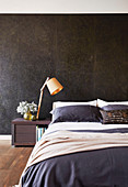 Black marble wall behind the bed in the bedroom