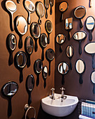 Ebony hand mirrors on wall of bathroom