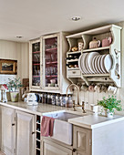 Plate rack and glass fronted cabinet above kitchen counter