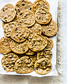 Chocolate Chip Cookies auf Backpapier (Aufsicht)