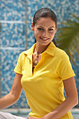 A young brunette woman wearing a yellow polo shirt