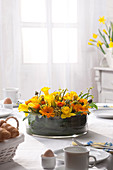 Blumentorte aus Ranunkeln, Osterglocken und Gerbera als Tischdekoration
