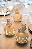 Illuminated porcelain spheres topped by whimsical animal figurines with a festive theme