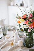 Vase of colourful flowers on Easter breakfast table
