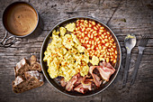 Breakfast with scrambled eggs, baked beans and bacon