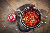 Tomato sauce in a pot being cooked on a gas burner