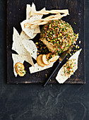 A cheese ball with nuts and crackers