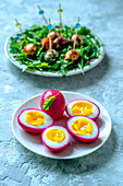 Chicken eggs, painted beet juice, quail eggs in a variety of spices and arugula