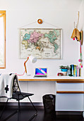 White desk above world map in home office