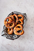 Homemade pretzels with seasme seeds in a wire basket