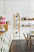 Festively decorated ladder in dining room next to open-plan kitchen