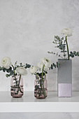 DIY-Vase im Beton-Look aus Milchtüte und Glasvasen mit Ranunkel