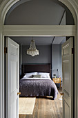 Blick durch offene Doppeltür ins Schlafzimmer in Grautönen