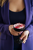 A raspberry cocktail with a rosebud rim