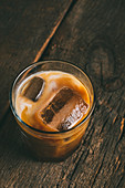 Eiskalter Kaffee mit Milch im Glas