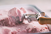 Homemade raspberry ice cream with an ice cream scoop