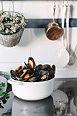 A bowl of mussels on a kitchen work surface