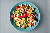 Top view of appetizing vegetables salad served with shrimps on a table
