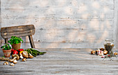 Gemüsestillleben mit Kräutern auf Holztisch