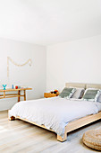 Doppelbett aus Massivholz und Konsole in weißem Schlafzimmer