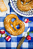 Lye bread with cheese and radishes on a blue and white tablecloth