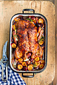 Roast duck with plums in a dish (top view)