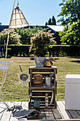 Shelves made from wooden crates on sunny terrace in garden