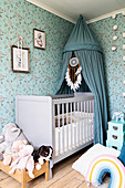 Blue canopy with dreamcatcher above cot in nursery