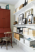Red bureau next to shelves decorated with ornaments in natural shades